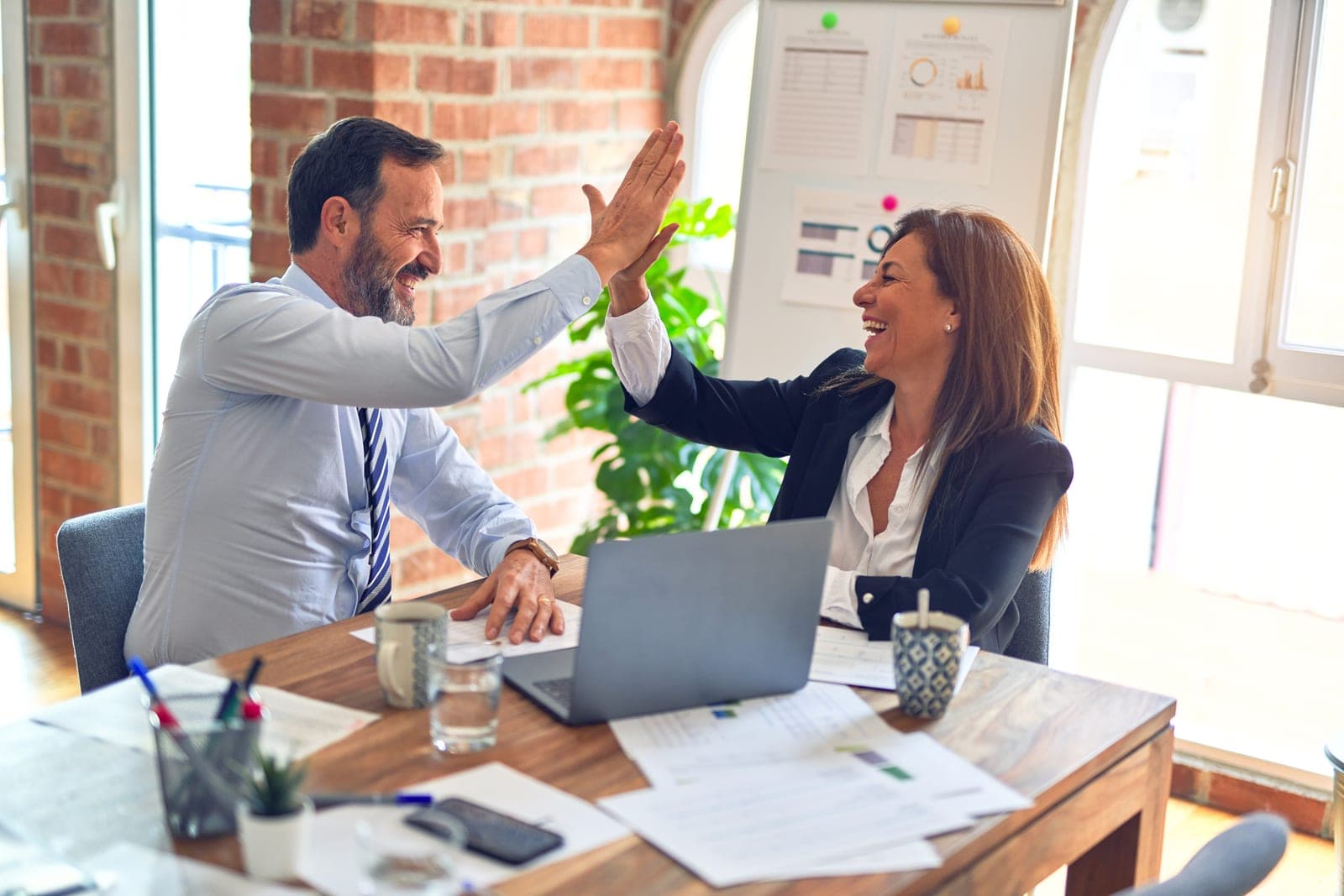Colleagues giving each other a 'high five' in the workplace